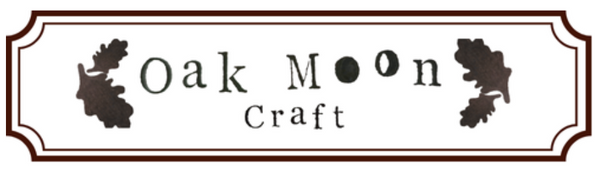A rectangular white label with a brown border and the words 'Oak Moon Craft' in dark brown lettering, flanked by two oak leaf silhouettes, on a plain white background.